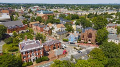 An aerial view of Salem, Massachusetts, historic red brick buildings interspersed with bright green trees.