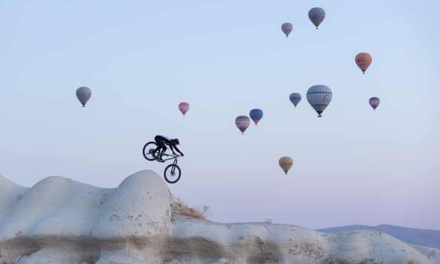 Killion Bron cabalga por las chimeneas de hadas de Capadocia bajo una nube de globos aerostáticos