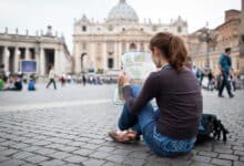 Creditos al poeta de la luz, hermosa joven turista estudiando mapas en Italia
