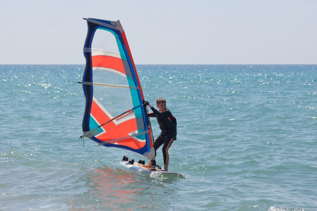 Windsurf en un día tranquilo con cielo azul claro y mar mediterráneo |  vacaciones familiares en Mallorca