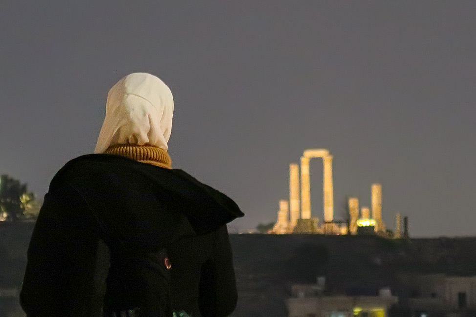 Mujer contemplando la ciudadela de Amman por la noche