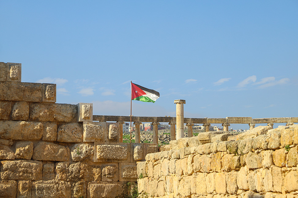 La bandera jordana entre ruinas históricas en el Museo Arqueológico de Jerash