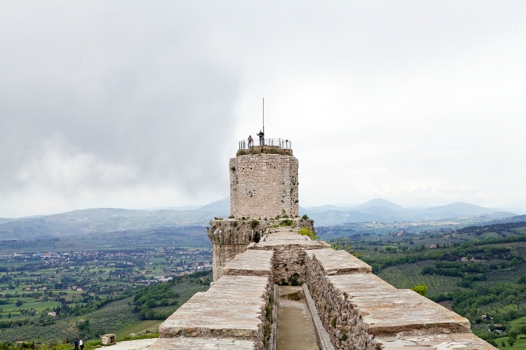 Los turistas visitan la Rocca Maggiore, Asís, Italia, con panorama.  Rocca Maggiore dominado por más de ochocientos años la ciudadela de Asís y el valle de Tescio.  Los primeros documentados sobre la fortaleza datan de 1173.