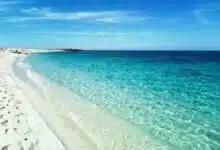 playas en cerdeña |  playa de arena blanca y agua azul bajo un cielo despejado |  es aruttas