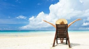 mujer sentada en una tumbona disfrutando de la vista a la playa