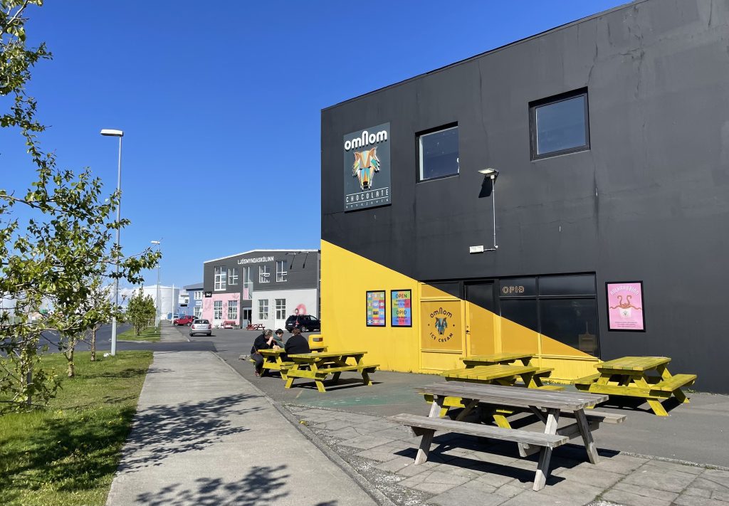 A yellow and black building with picnic tables outside in the industrial chic Grandi Harbor District of Reykjavik.