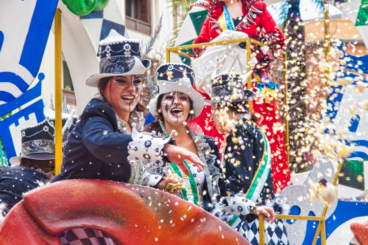 cosas que hacer en andalucia |  ALGECIRAS, ESPAÑA - 5 DE MARZO DE 2017: Los participantes del carnaval de risa alegre lanzan confeti durante el desfile del carnaval en la calle en Algeciras, Cádiz, Andalucía