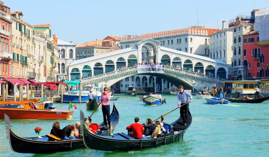 Góndola veneciana en primer plano del canal con el Puente de Rialto al fondo