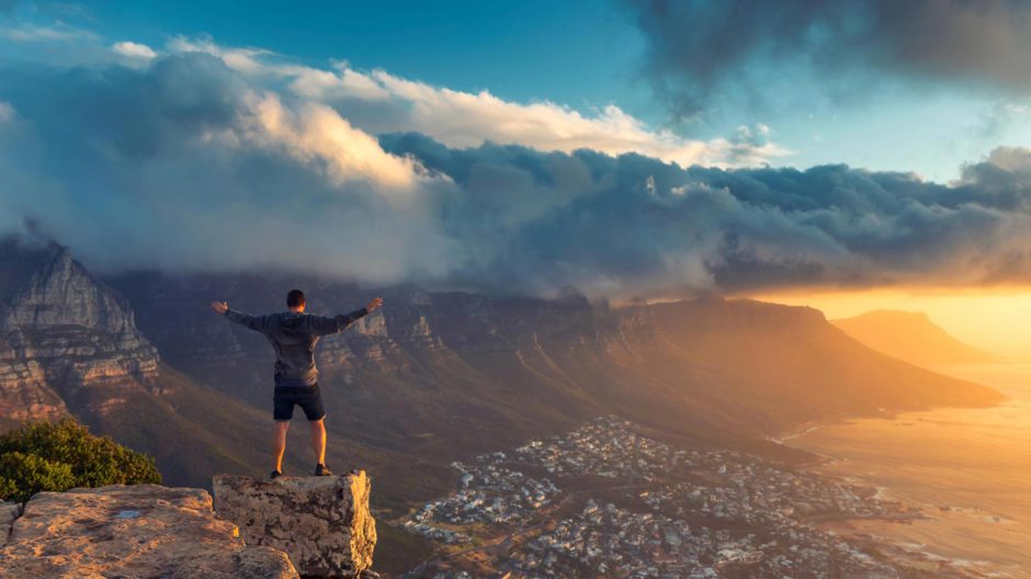 hombre de pie en el borde de Lion's Head en Ciudad del Cabo