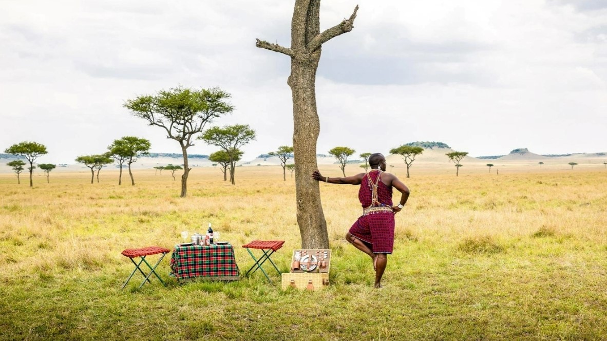 Los miembros de la tribu Maasai Mara contemplan las vastas llanuras de Mara mientras esperan a los invitados para un desayuno en la selva.