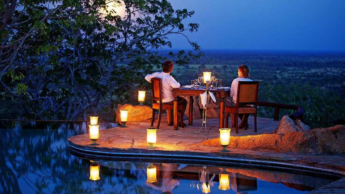 Disfruta de una cena privada en la terraza de la piscina iluminada por farolillos que brillan suavemente