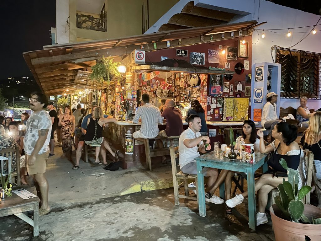 Crowds of people at an outdoor ramshackle bar in Sayulita.
