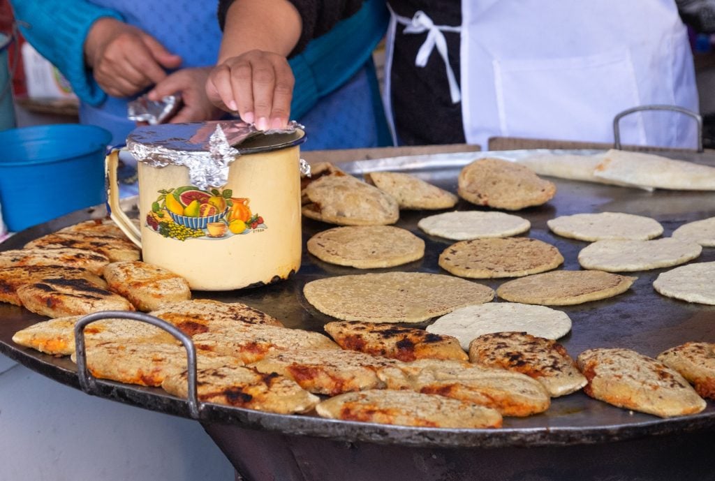 A big pan where a woman cooks fresh corn tortillas.