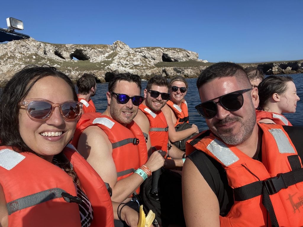 Kate and a group of friends all wearing orange lifejackets and sunglasses, out on the water in Mexico.