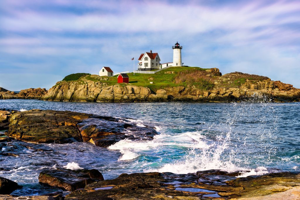 A lighthouse perched on an island off the coast of Maine.